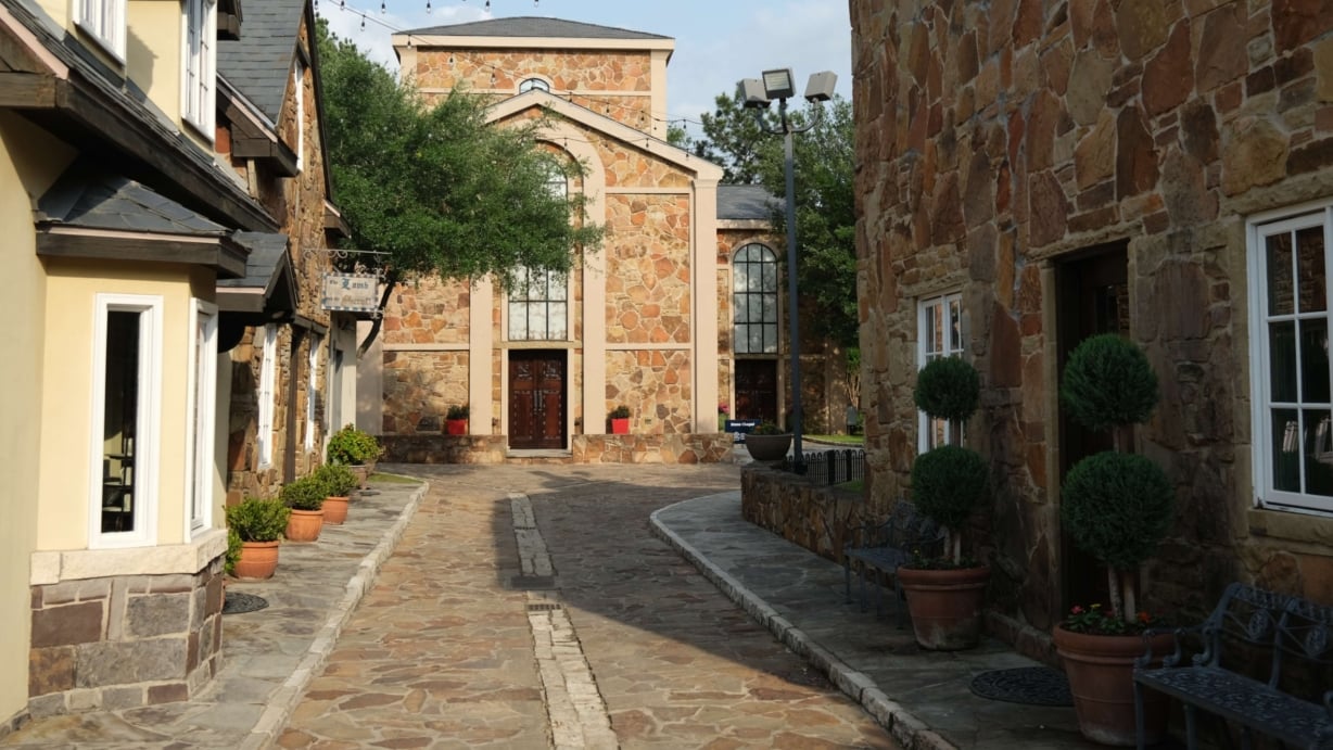 English style buildings line either side of a stone walkway leading to the Stone Chapel.