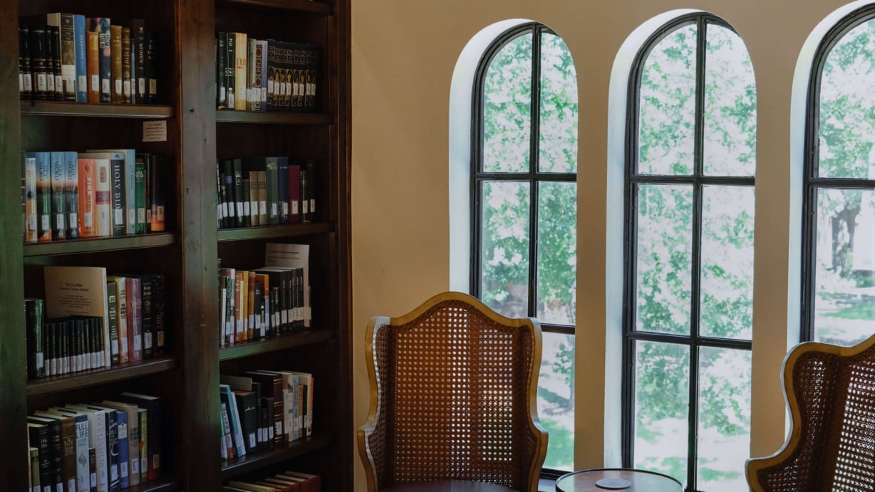 Four chairs face each other in an alcove upstairs in the library.