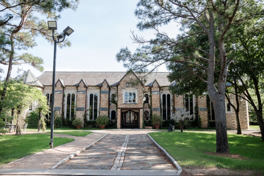 The front entrance of the library with trees on either side of a stone pathway