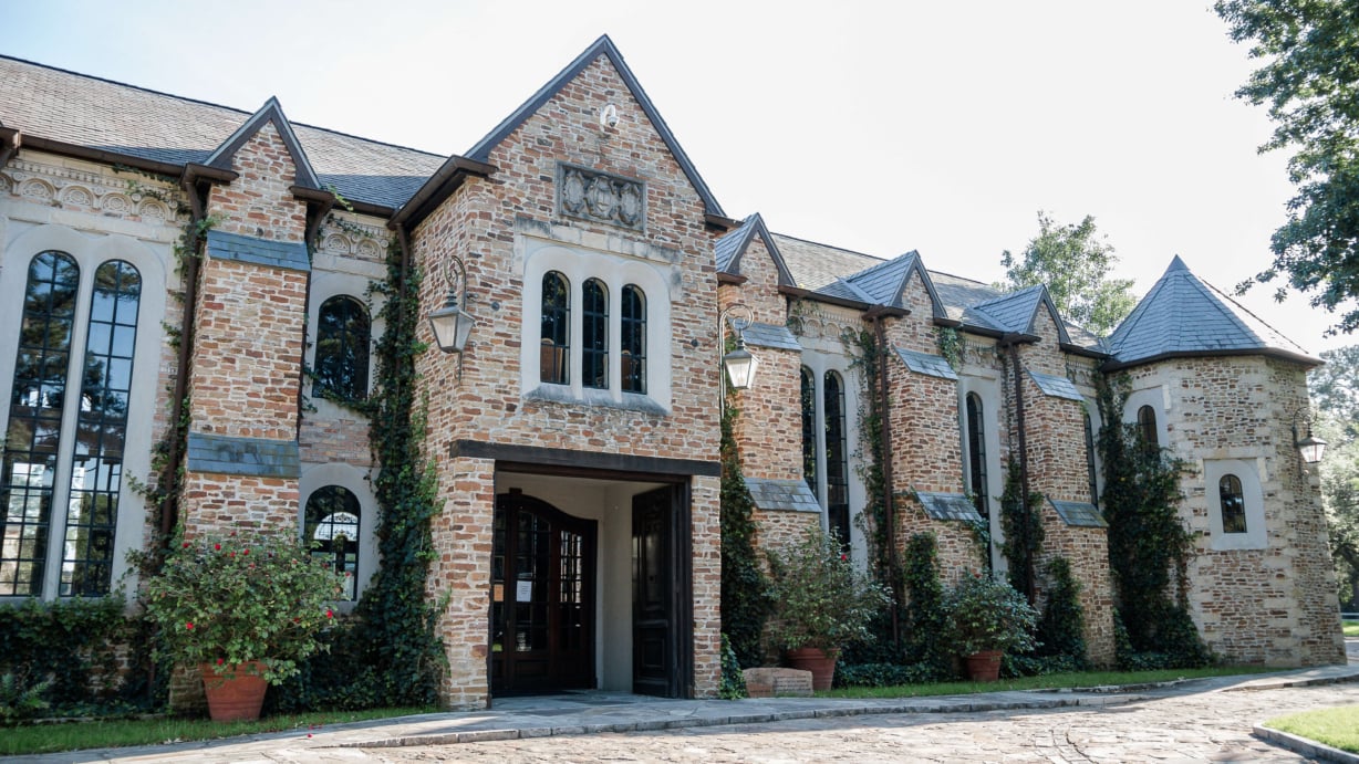 The front entrance of the library. Bushes sit on either side of the double doors, and vines grow up the front of the building.